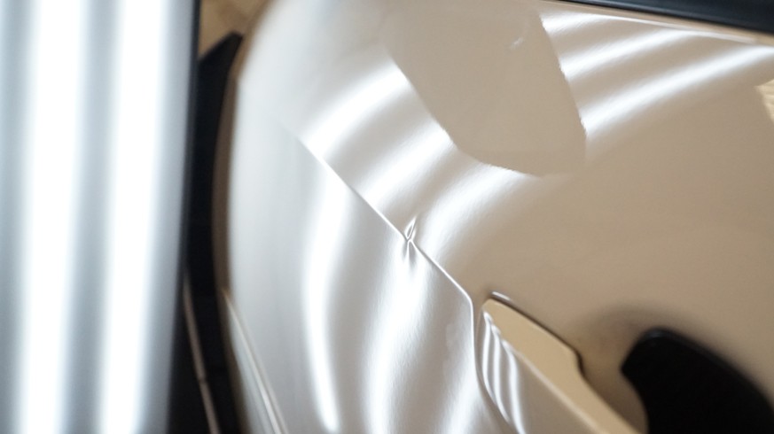 white car with dents in cover